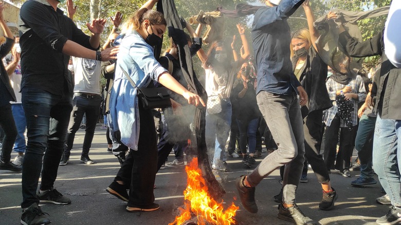 protestors dancing and burning hijabs