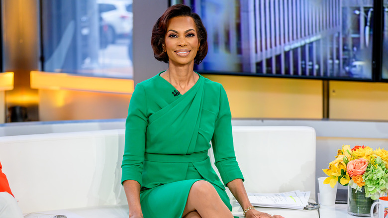 Harris Faulkner sitting on a couch wearing a green dress