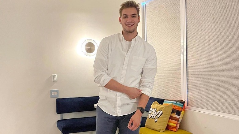 Luke Cameron smiling in dress shirt and pants