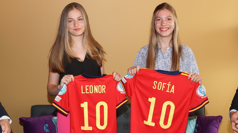 Infanta Sofía and Princess Leonor holding soccer jerseys