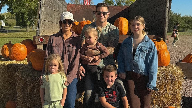 Chelsea Houska poses for a photo in a pumpkin patch with her family