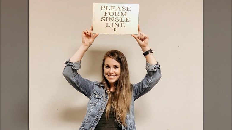 Jana Duggar smiling with sign