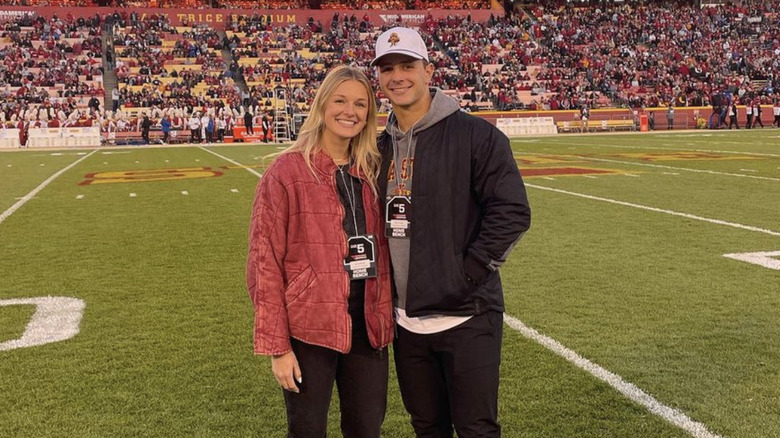 Jenna and Brock Purdy pose on a football field