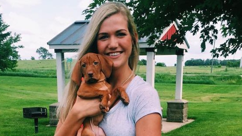 Kassidy Noem Peters smiling and holding a dog