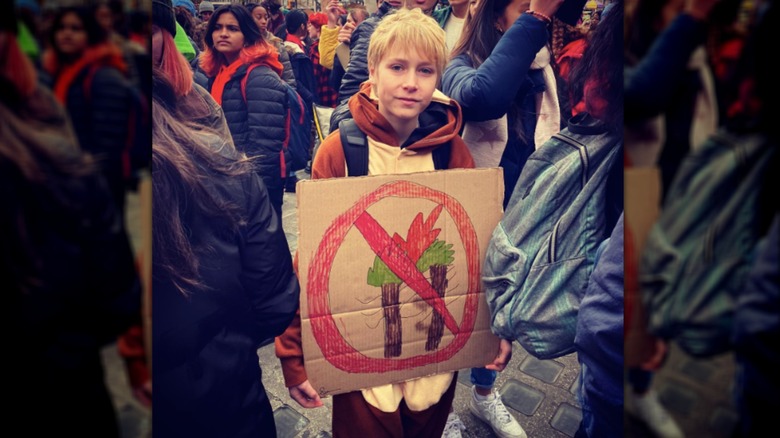 Sasha Schreiber holding protest poster