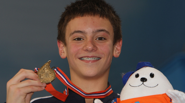 Young Tom Daley smiling with a medal 