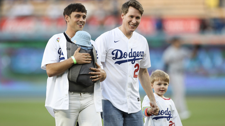 Tom Daley walking with husband Dustin Lance Black and two sons