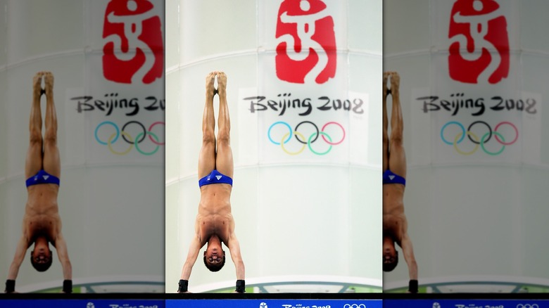 Tom Daley doing a handstand on a diving board 