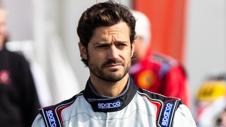 Prince Carl Philip looking concerned in a racing jacket