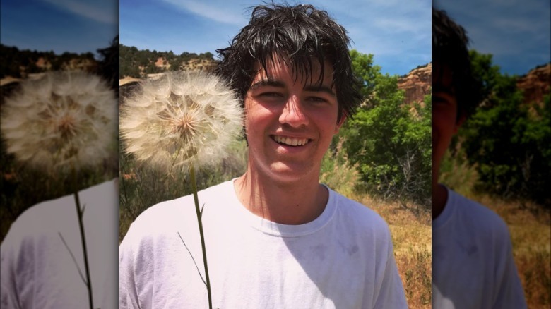 William Finbar Kennedy holding a dandelion