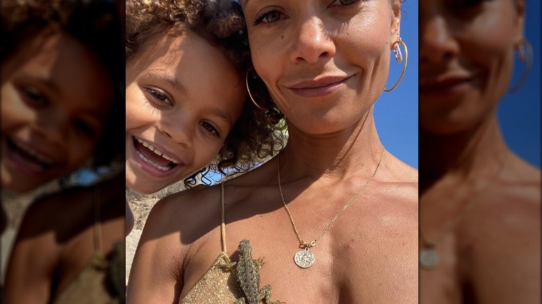 Booker Parker and Thandiwe Newton smiling with lizard