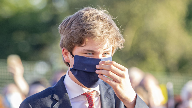 Prince Gabriel walks outdoors wearing a face mask.