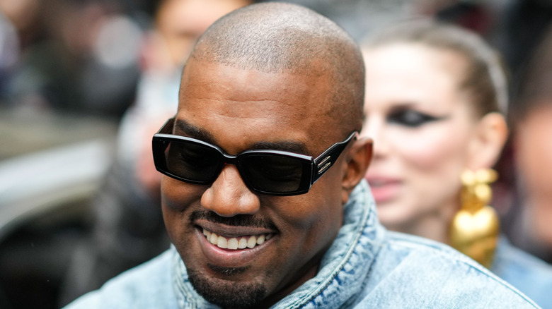 Kanye West smiling and wearing sunglasses