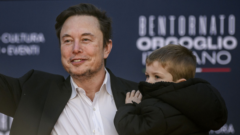 Elon Musk carrying one of his sons