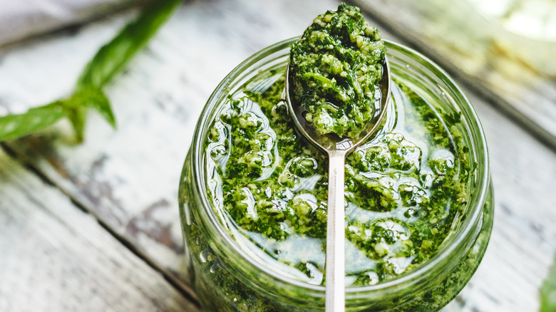 A jar of pesto with a spoon