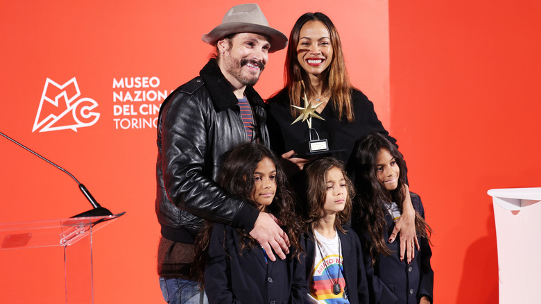 Zoe Saldaña and her husband posing for photos with their sons