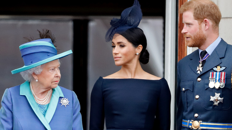 The queen looks sternly at Meghan Markle and Prince Harry