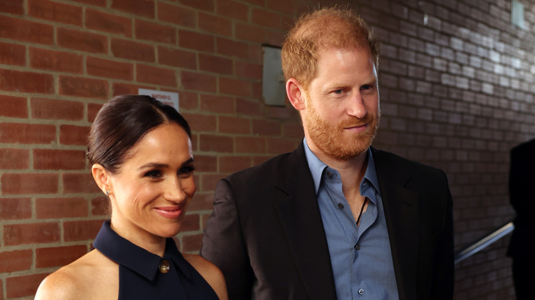 Meghan Markle smiling next to Prince Harry