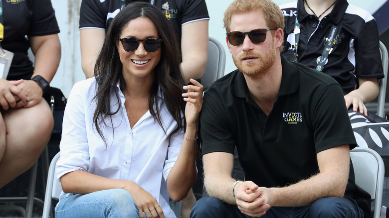 Meghan Markle and Prince Harry sitting together watching an event