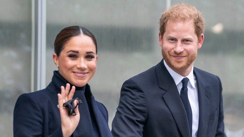 Meghan Markle waving and Prince Harry smiling
