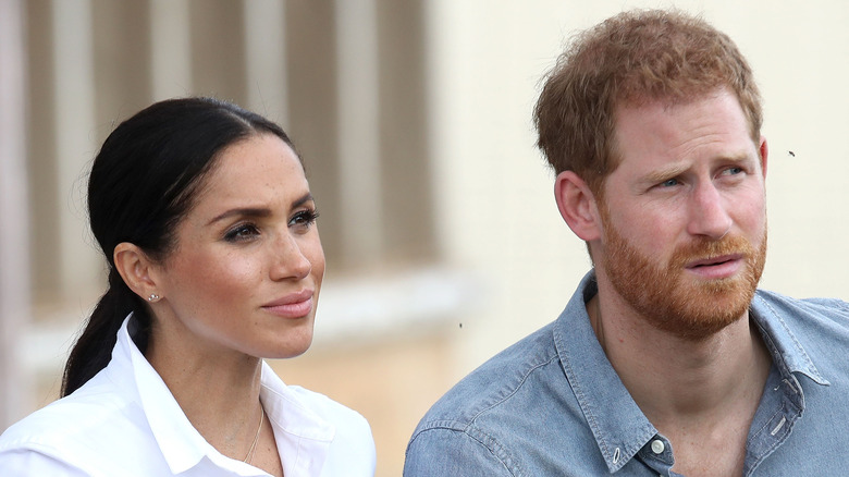 Meghan Markle and Prince Harry listening intently