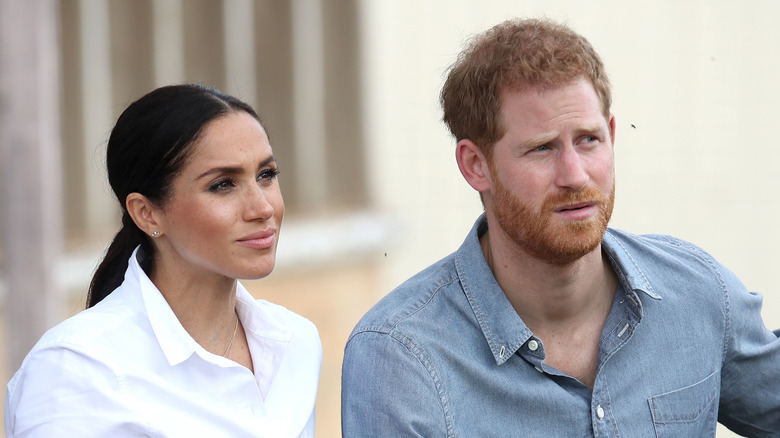 Meghan Markle and Prince Harry listening intently