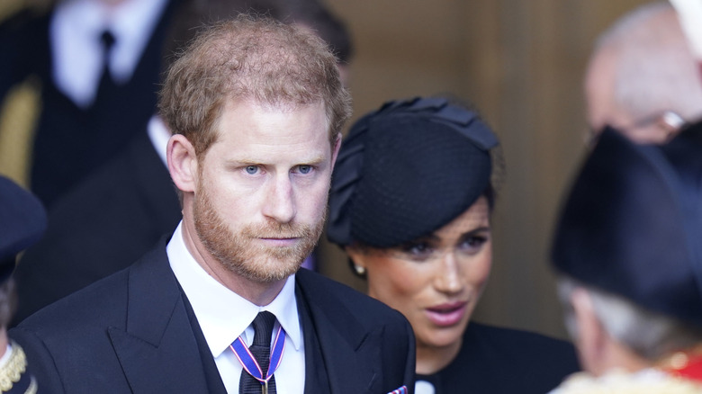 Prince Harry looks stony-faced as he and Meghan Markle attend the queen's funeral