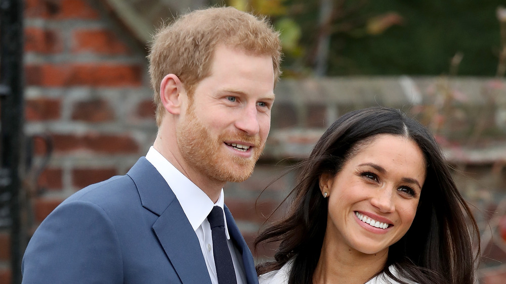 Meghan Markle and Prince Harry smile for photographers