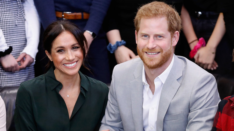 Prince Harry and Meghan Markle smiling at an event