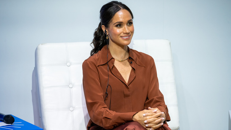 Meghan Markle during a 2024 visit to EAN University sitting with her hands folded