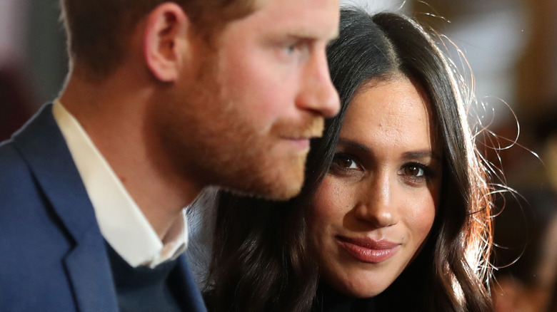 Meghan Markle with Prince Harry in the foreground