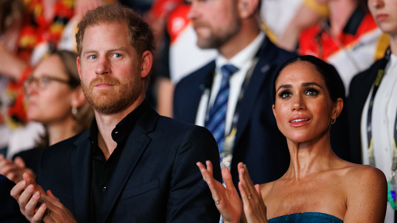 Prince Harry and Meghan Markle standing and clapping