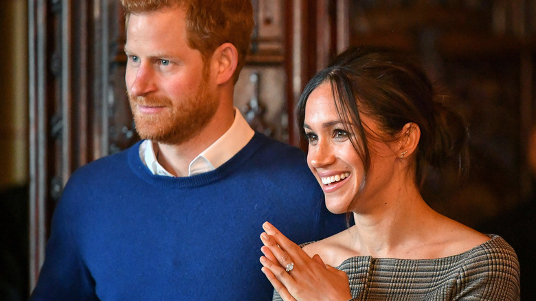 Prince Harry and Meghan Markle smiling together for a photo