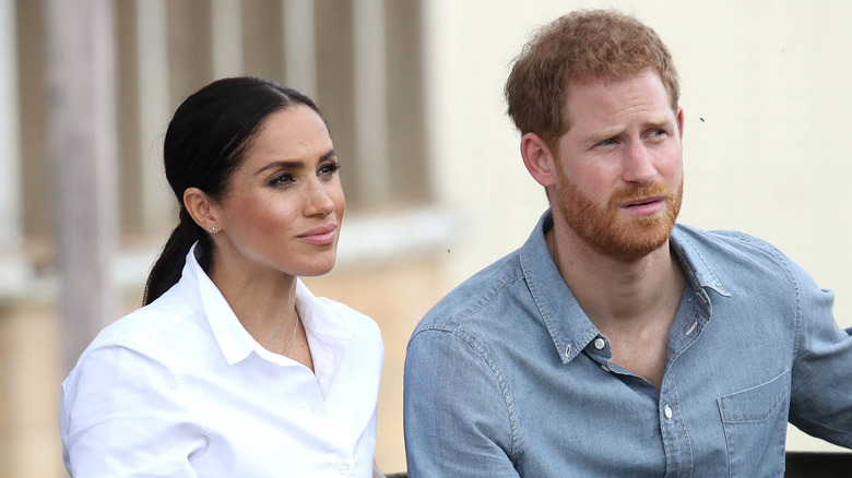 Meghan Markle and Prince Harry listening intently