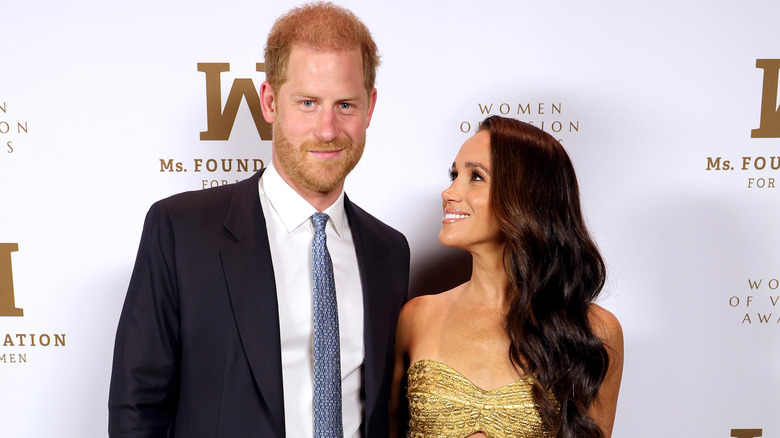 Harry and Meghan smiling on red carpet