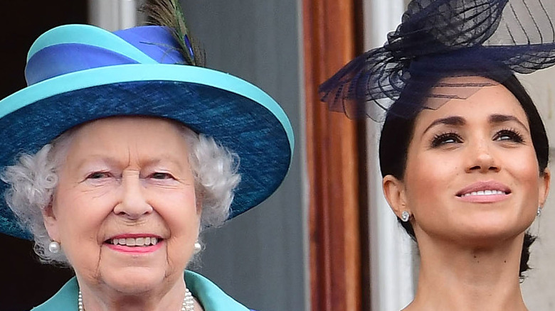 Queen Elizabeth and Meghan Markle smiling at event