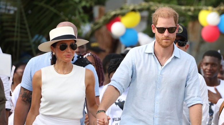 Meghan Markle holding hands and walking alongside Prince Harry