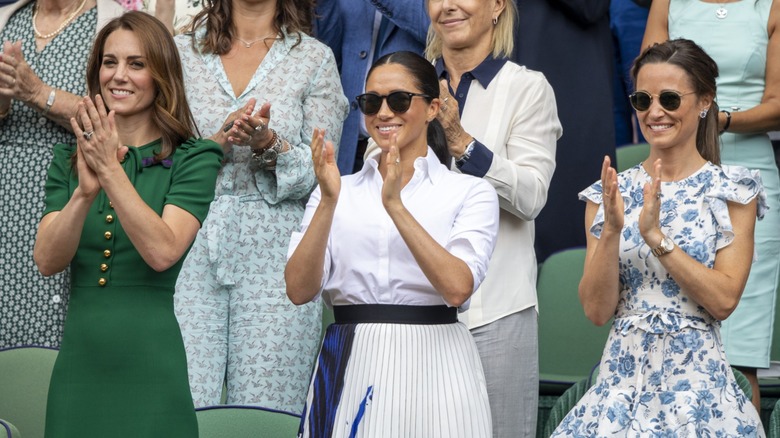 Kate Middleton, Meghan Markle, Pippa Middleton standing, appluading