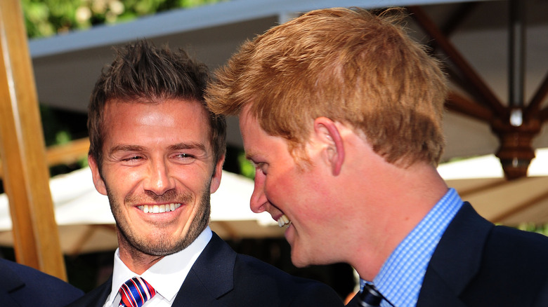 Young David Beckham and Prince Harry smiling at each other