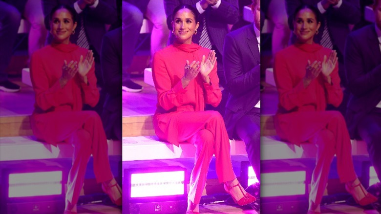 Meghan Markle clapping in an all-red outfit at the One Young World summit