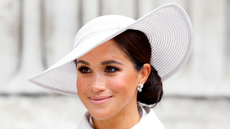 Meghan Markle smiling in a big hat