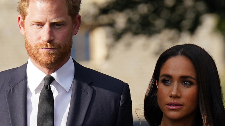 Harry and Meghan looking somber