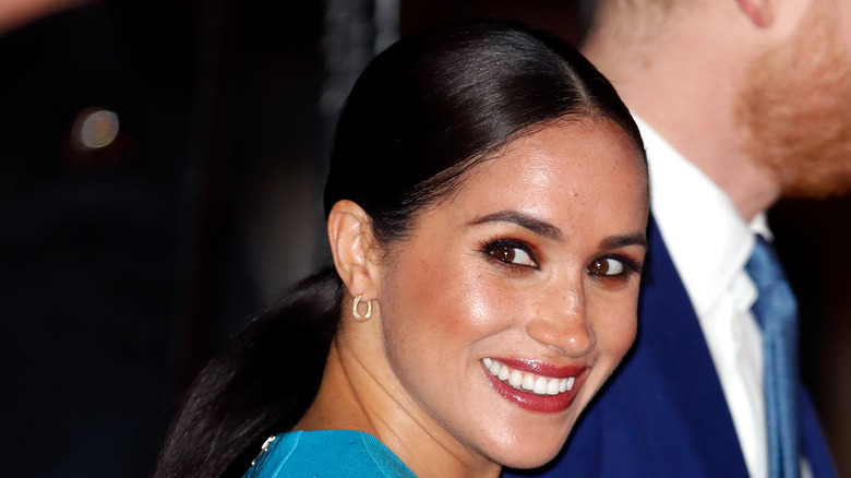 Meghan Markle smiling over her shoulder