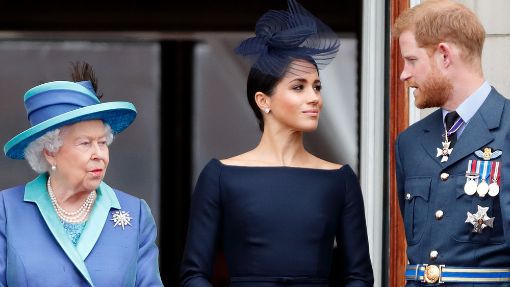 Queen Elizabeth, Meghan Markle, and Prince Harry looking serious