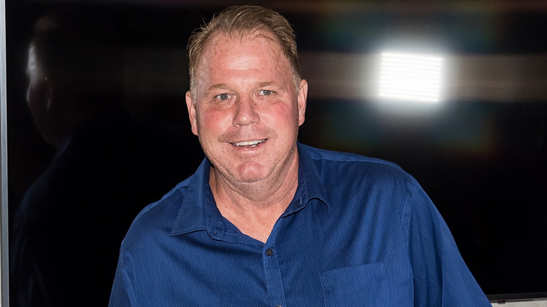 Thomas Markle Jr. smiles, wearing a navy blue button up shirt