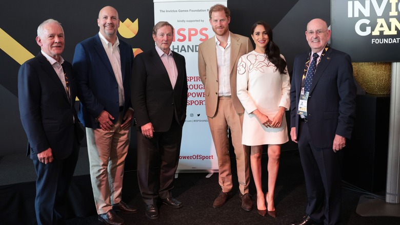 Meghan and Harry posing with Invictus representatives