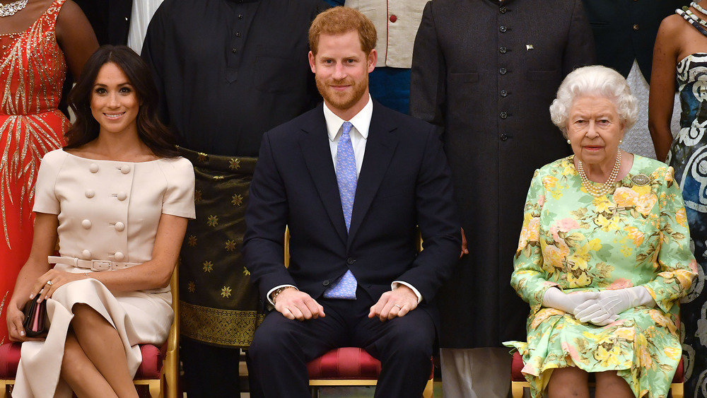 Meghan Markle sits with Prince Harry and the Queen