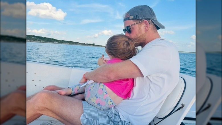 Prince Harry holding Lilibet on a boat