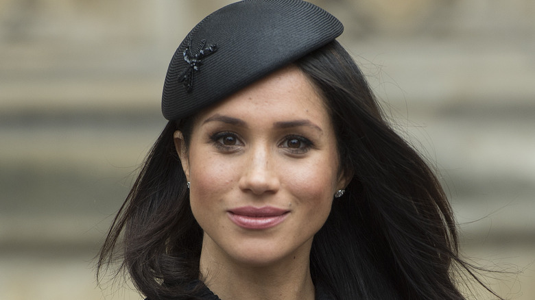 Closeup of Meghan Markle in black fascinator