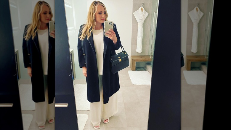 Meghan McCain wearing flowy white slacks and white blouse, topped with heavy blue winter coat